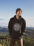 Black pullover hoodie with hood and circular “Adventure” logo on the chest.