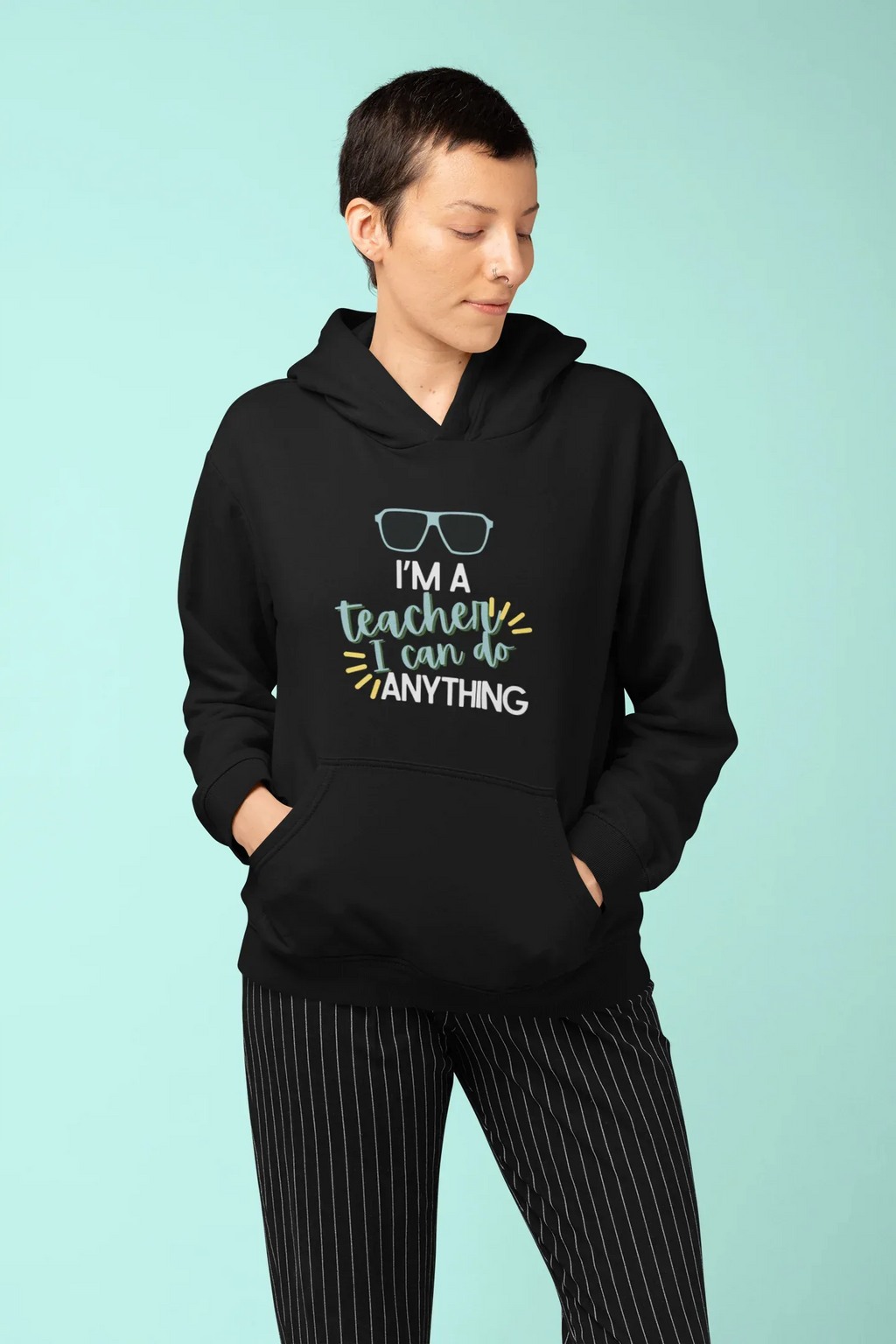 Black unisex hoodie worn by model, with hood and colorful teacher slogan graphic