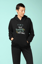 Black unisex hoodie worn by model, with hood and colorful teacher slogan graphic