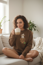 Brown sloth graphic sweatshirt with "Don't Rush Me" text, worn while holding a mug
