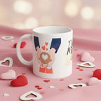 White ceramic coffee mug with blue-sleeved hands holding a heart and red heart icons