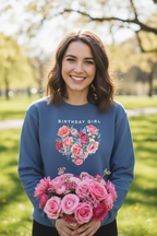 Blue crewneck sweatshirt worn by a person, with “Birthday Girl” and floral heart design