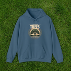 Indigo blue unisex hoodie on green grass, with “Plant More Trees” chest graphic