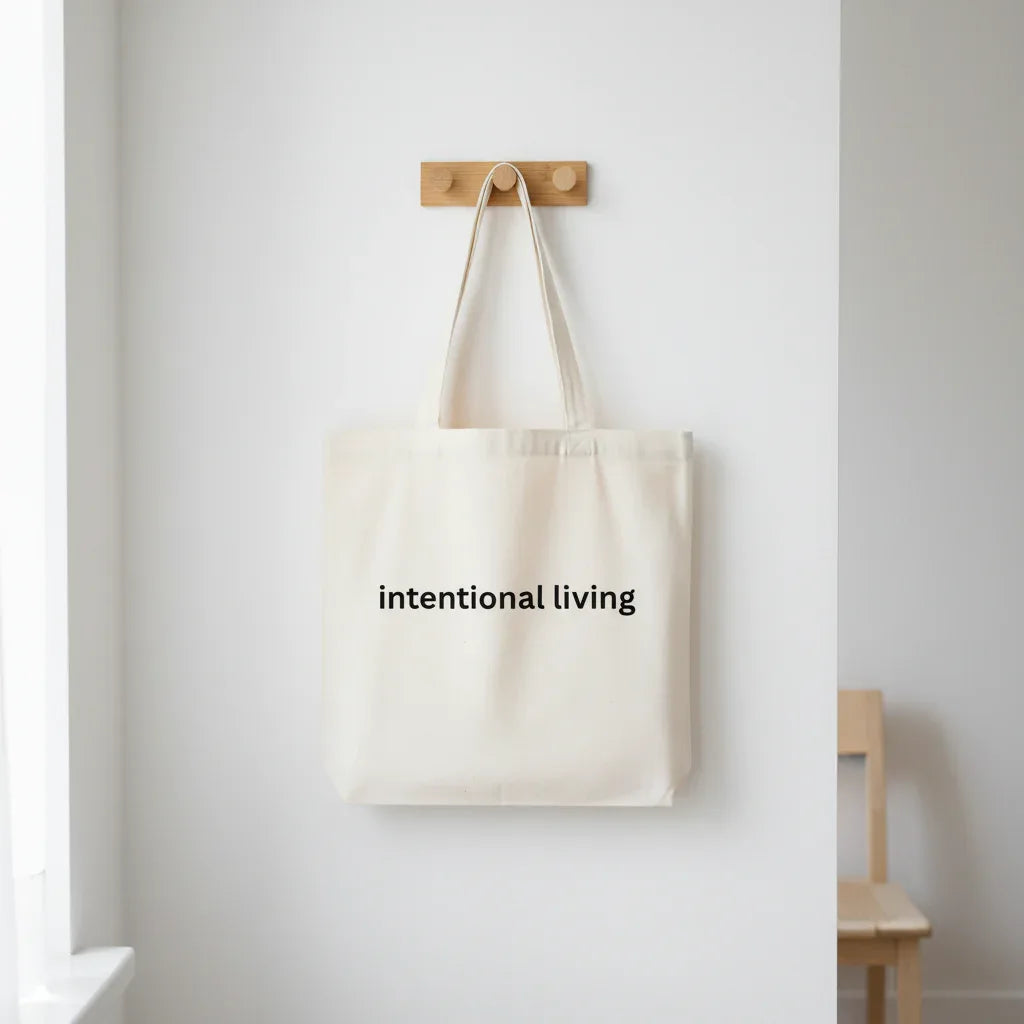White cotton tote bag with two short handles, printed “intentional living”