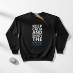 Black crewneck sweatshirt with large “KEEP CALM AND ENJOY THE waves” print on chest.