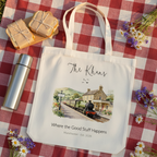 White canvas tote bag with a printed train station landscape illustration.