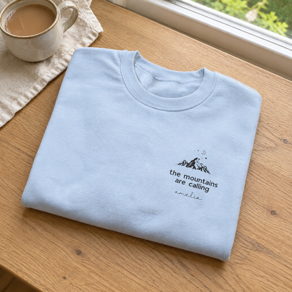 Light-blue Mountains Are Calling sweatshirt in a natural cottage setting