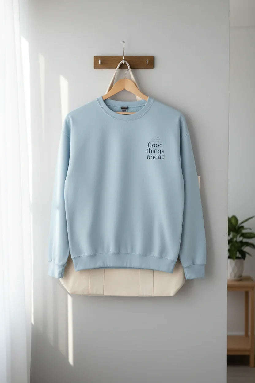 Light blue crewneck sweatshirt with "Good things ahead" chest print