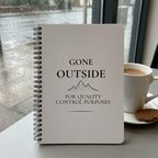 Light grey Gone Outside notebook on a café table