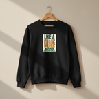 Black crewneck sweatshirt with front graphic print, hanging on a wooden hanger