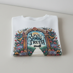 Graphic t-shirt with multicolor arch front print and script text, light-colored base.