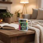 White ceramic mug with green and pink “Introverted but Outdoorsy” graphic and text.
