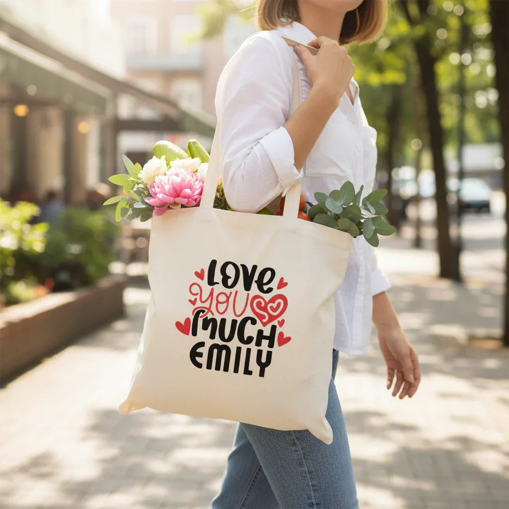 White tote bag with 'LOVE YOU MUCH EMILY' heart text print.