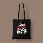 Black tote bag with printed hearts and text: “LOVE YOU MUCH HAYLEY”