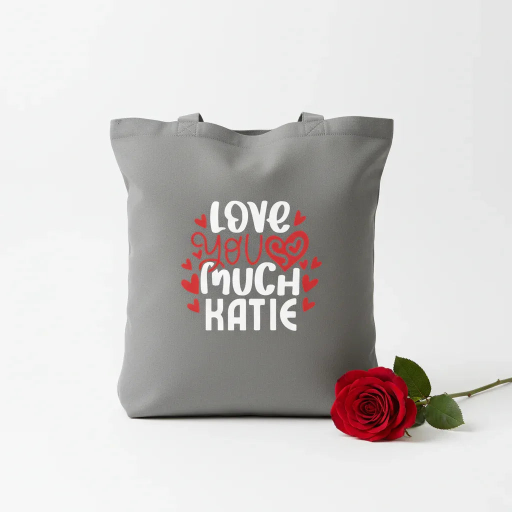 Grey tote bag with printed hearts and text: “LOVE YOU MUCH KATIE”