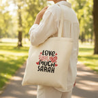 White tote bag with 'LOVE YOU MUCH SARAH' heart text print.