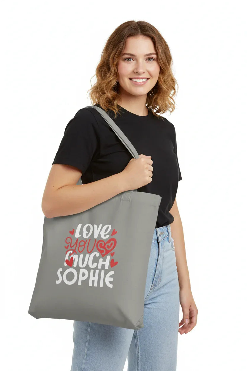 Grey tote bag carried over the shoulder with printed hearts: “LOVE YOU MUCH SOPHIE”