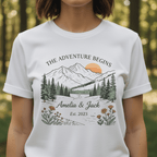 White T-shirt worn by model, mountain landscape graphic with floral custom names