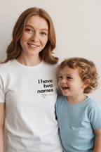 White crew-neck T-shirt with 'I have two names' print and heart graphic on chest.