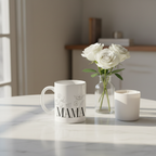 White ceramic coffee mug with floral line art and 'MAMA' on a table