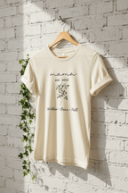 Natural cream T-shirt with “mama est. 2022” script, floral bouquet, and “Willow • Beau • Nell”