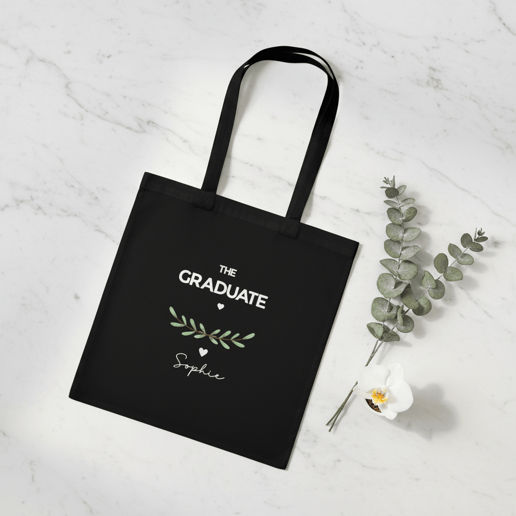 Black graduation tote bag with “THE GRADUATE” and green laurel, name Sophie