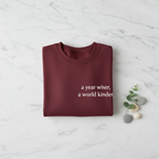 Maroon sweatshirt with “a year wiser, a world kinder.” front lettering.