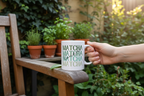 White ceramic matcha mug with green MATCHA text, hand holding