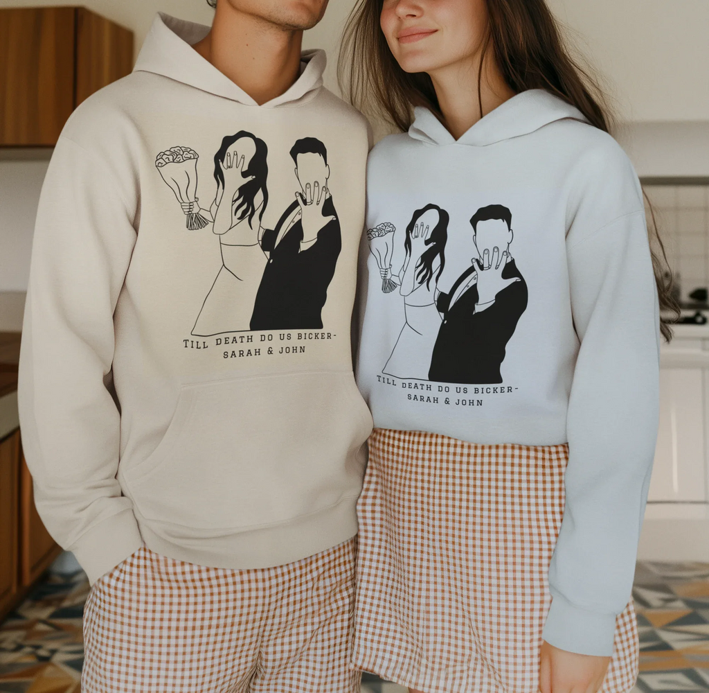 White and light-blue couple graphic hoodies worn together, front prints and hood.