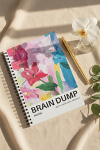 A5 spiral notebook with floral “BRAIN DUMP” cover and assorted stationery nearby