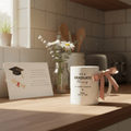 Personalised graduate mug on desk, white with 'IT'S A GRADUATE thing' for MAYA, 2026