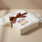 White t-shirt with stacked MEGAN text graphic and brown ribbon