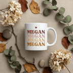 White ceramic mug with heart above stacked MEGAN text and round handle