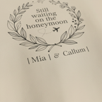 Beige hoodie print: 'Still waiting on the honeymoon' wreath with 'Mia I & Callum I'