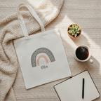 White canvas tote bag with rainbow arch print and name Mia on front panel