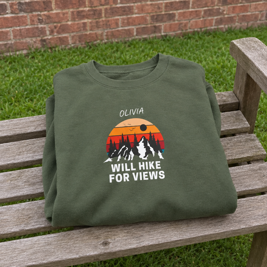 Military-green Will Hike for Views sweatshirt on a garden bench