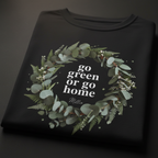 Black unisex T-shirt, folded, with “go green or go home” wreath graphic