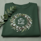 Forest green unisex T-shirt, folded, with “go green or go home” wreath graphic