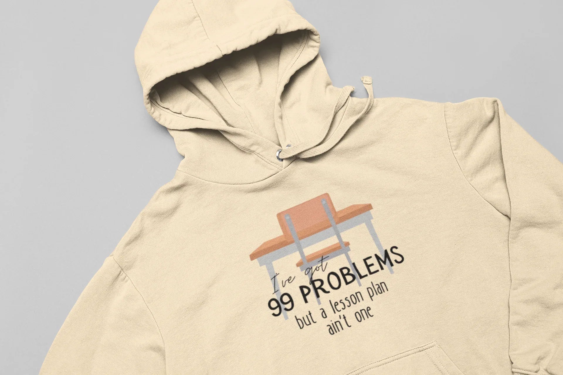 Beige unisex hoodie with drawstring hood and chest graphic; '99 problems' desk print.