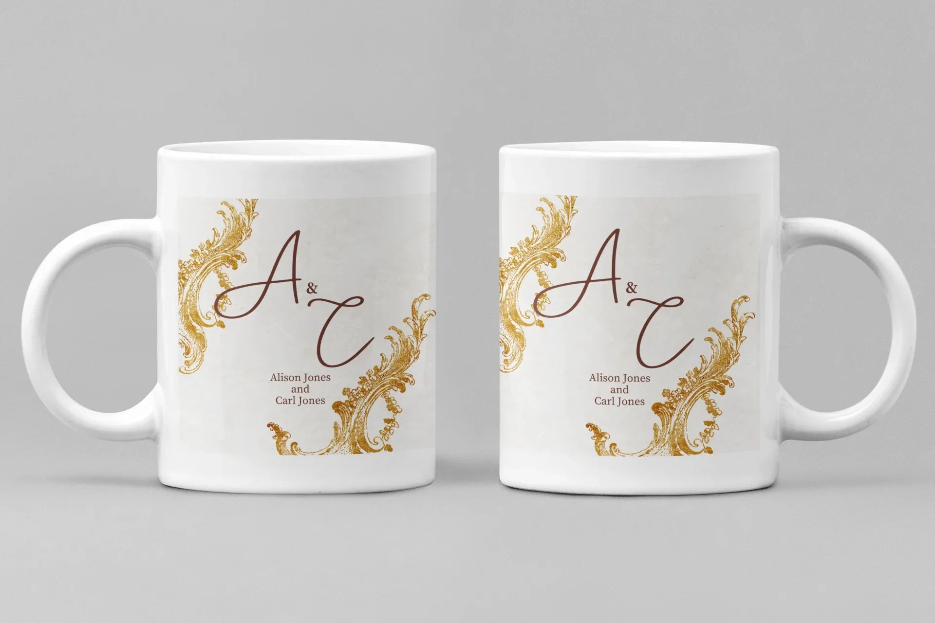 Pair of white mugs with gold filigree and dark red monogram design