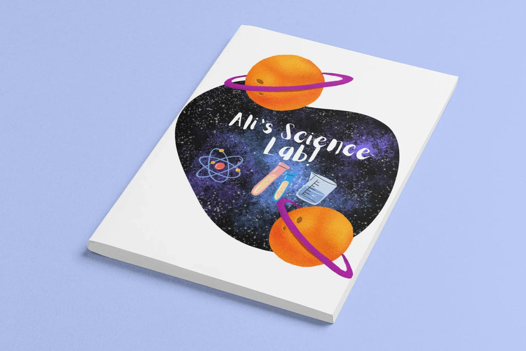 Closed science-themed journal with purple heart, orange planets, and “Alien’s Science Lab!”