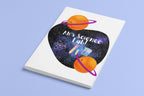 Closed science-themed journal with purple heart, orange planets, and “Alien’s Science Lab!”