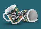 White ceramic mug angled left and right, showing 'STAY WILD!' print