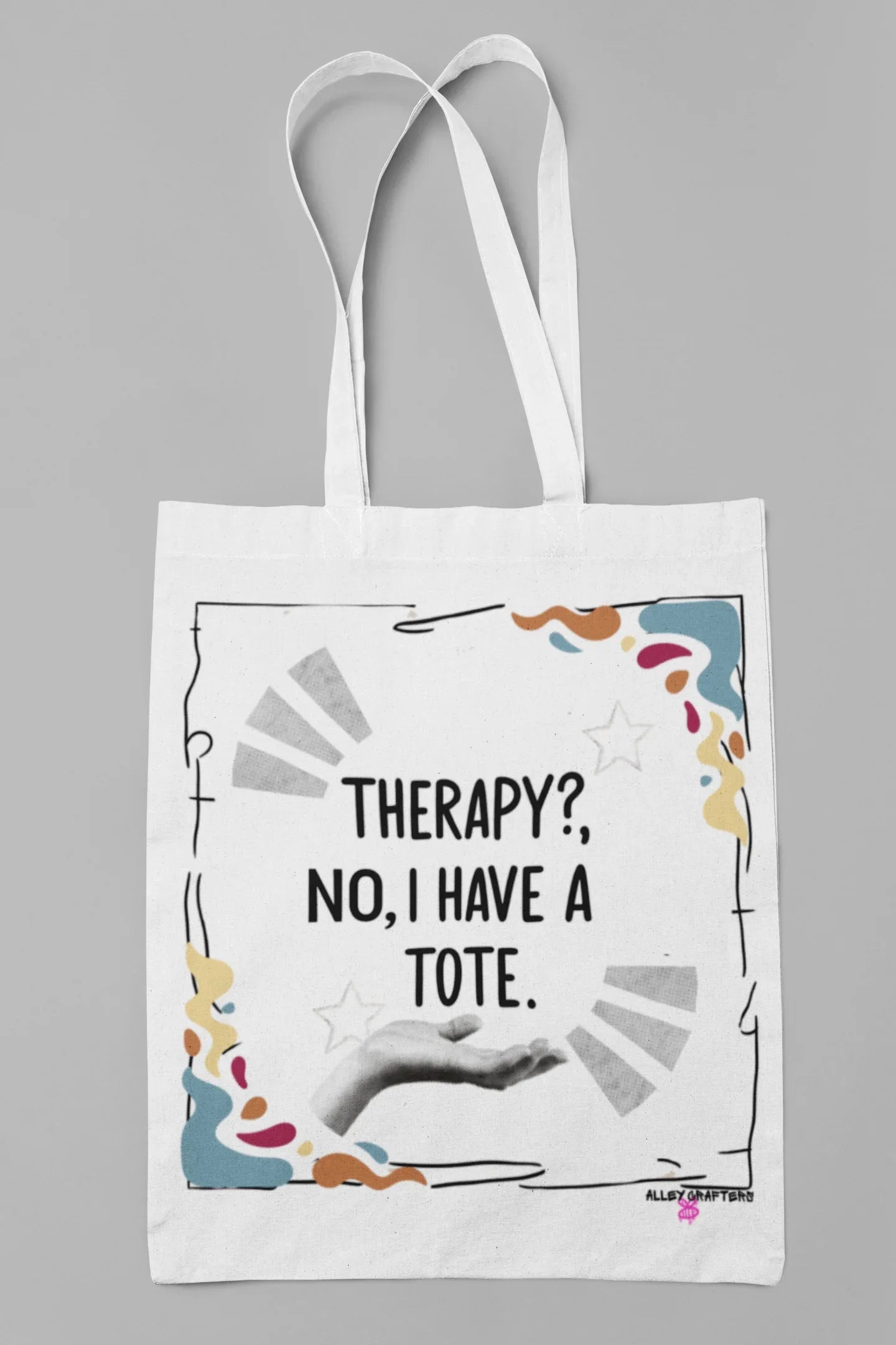 White tote bag with “Therapy?, No, I have a Tote” print and colorful border, white handles