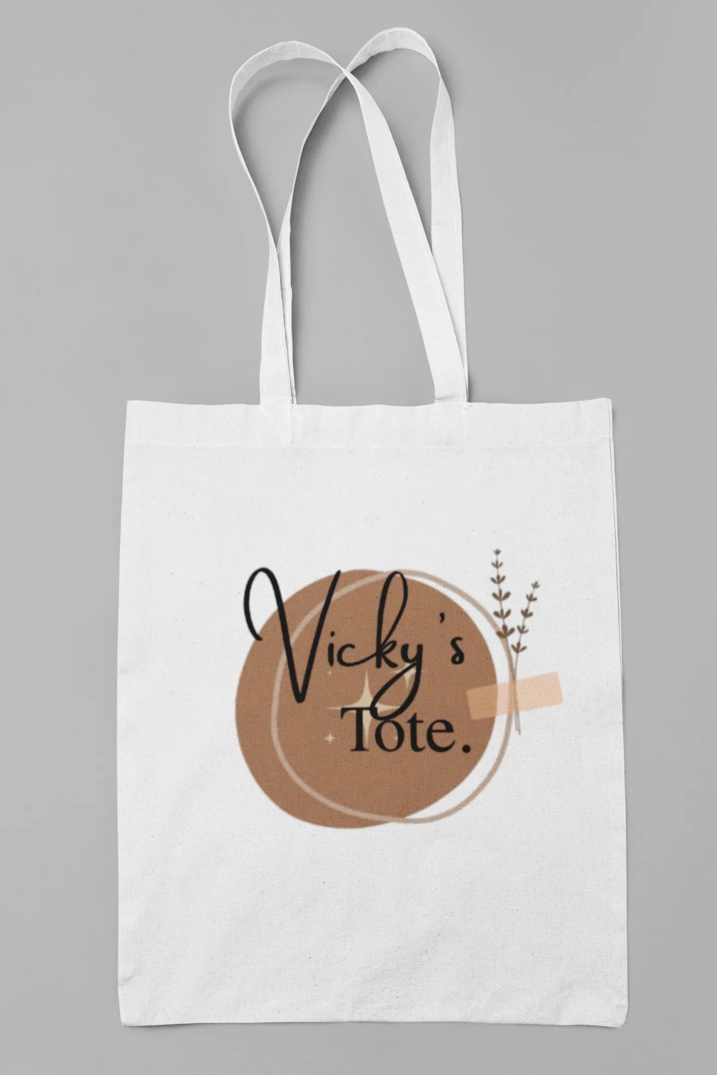White cotton tote bag with circular “Vicky’s Tote” print and small botanical sprig
