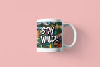 White ceramic mug with 'Stay Wild!' landscape graphic wrap and curved handle