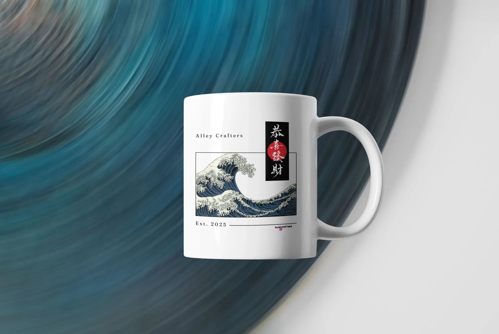 White mug with blue ocean wave artwork and red/black vertical emblem, side view.
