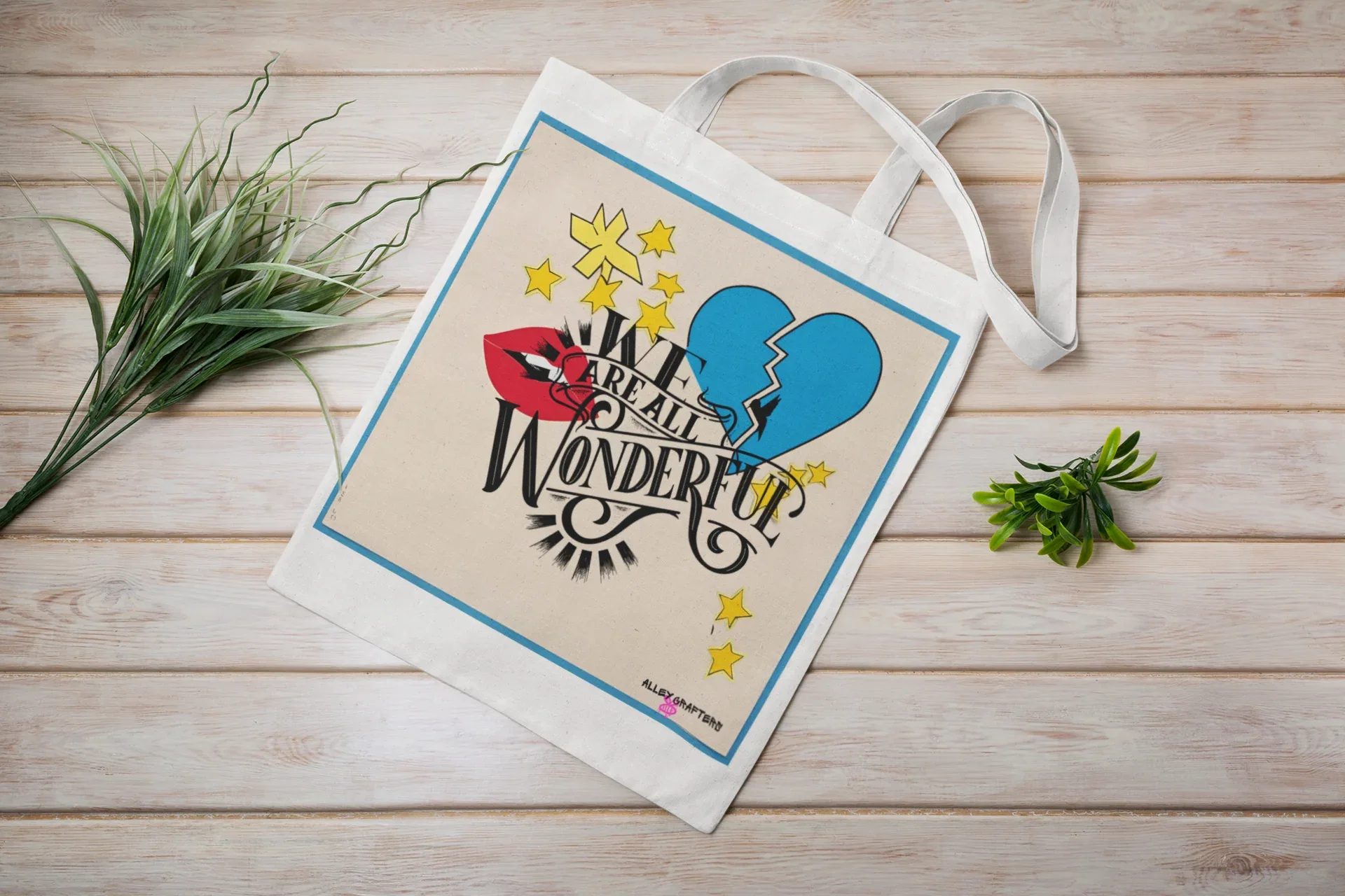 Light canvas tote bag with blue trim, handles, and colorful front graphic