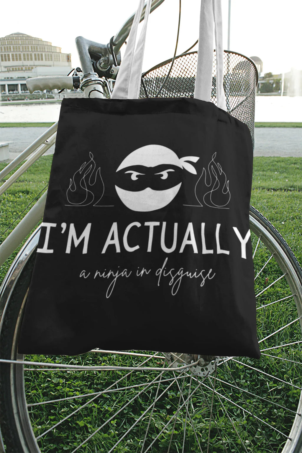 Black tote bag with ninja face graphic, 'I'M ACTUALLY', and 'a ninja in disguise'.