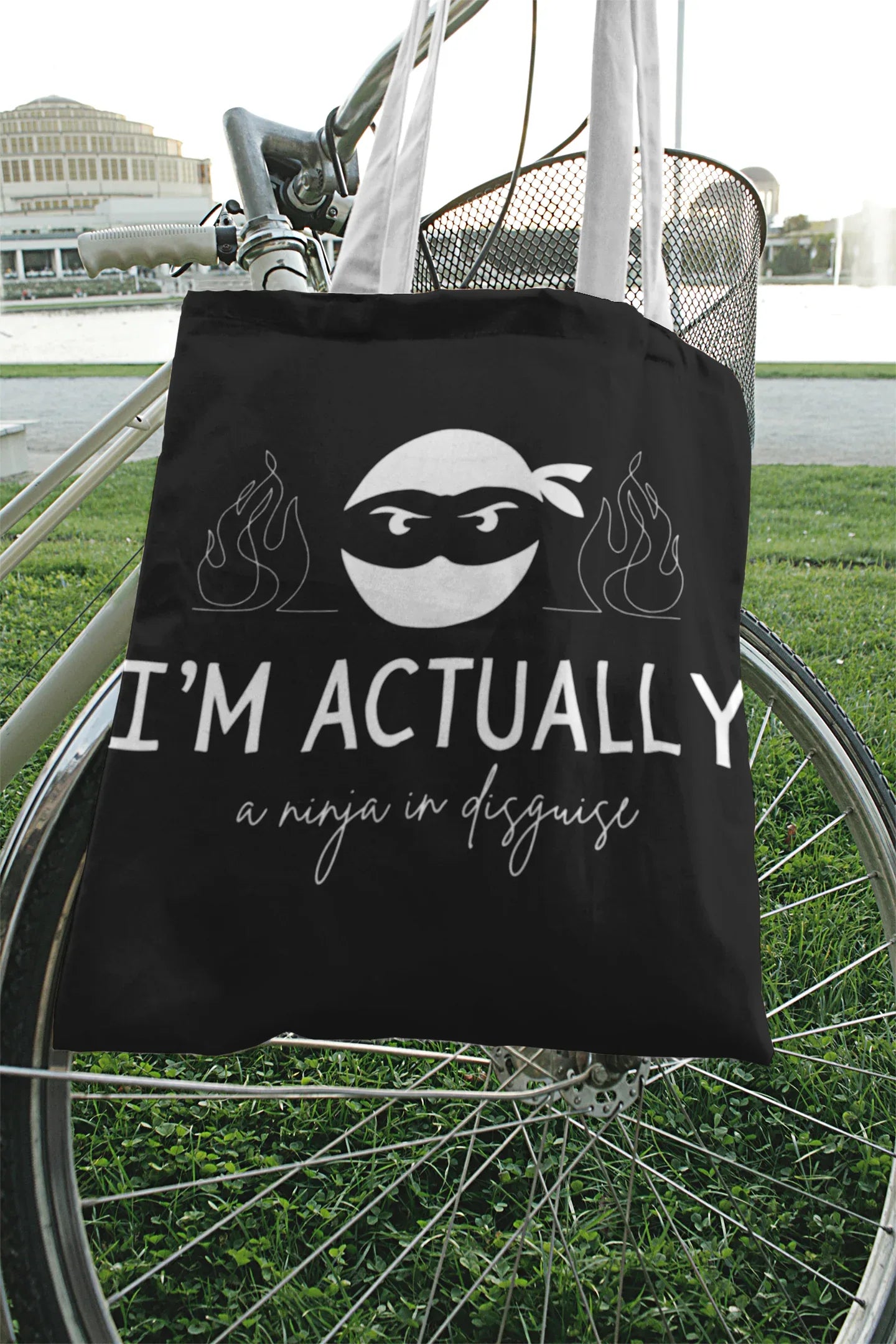 Black tote bag with ninja face graphic, 'I'M ACTUALLY', and 'a ninja in disguise'.